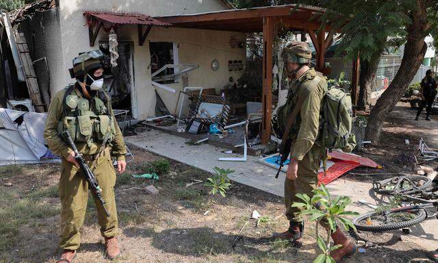Israelische Soldaten sichern den Kibbuz Kfar Aza und bergen Leichen aus den zerstörten Häusern.