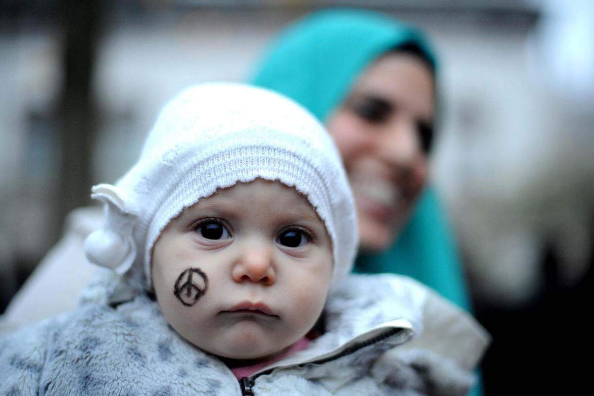 Dieses Baby auf einer Solidaritätskundgebung in Mailand hat den Friedens-Eiffelturm aufs Gesicht gemalt bekommen - als Tribut an die Opfer der Attacken in Paris.