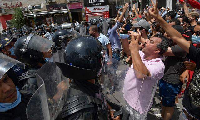 Sicherheitskräfte halten aufgebrachte Demonstranten vor dem Parlament in Tunis in Schach.