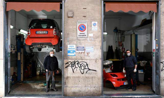 Mit Italien liegt Österreichs drittstärkster Handelspartner in wirtschaftlicher Agonie. Im Bild zwei Mechaniker am Donnerstag in ihrer Werkstatt in Rom.
