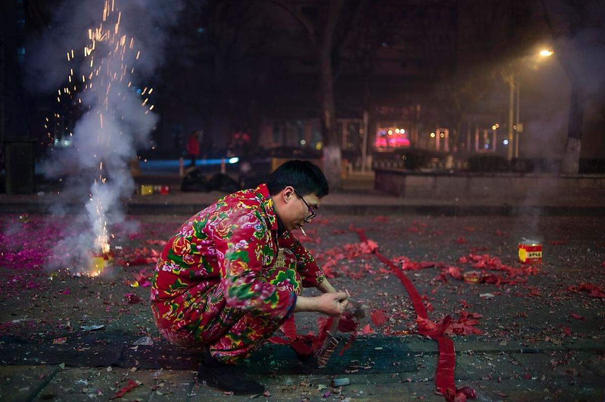 Auch in China wird Neujahr mit dem Krach von Böllern und Feuerwerken begrüßt. Hier etwa von einem Kellner in Peking, der nach seinem Dienst noch ordentlich feiert.