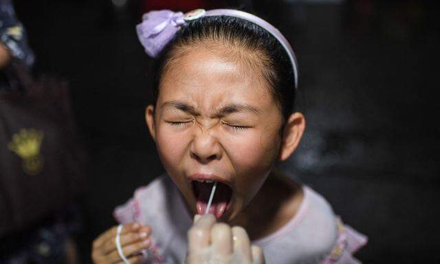 Archivbild eines Mädchens, das sich im August des Vorjahres in Wuhan einem Coronatest unterzieht.  