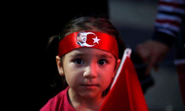 A young girl wears a head scarf depicting Turkish President Tayyip Erdogan during a pro-government demonstration in Ankara, Turkey