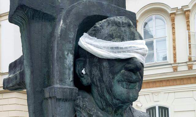 Mitglieder von „Scientist for Future“ haben das Figl-Denkmal am Wiener Minoritenplatz um Augenbinde und Ohrstöpseln erweitert