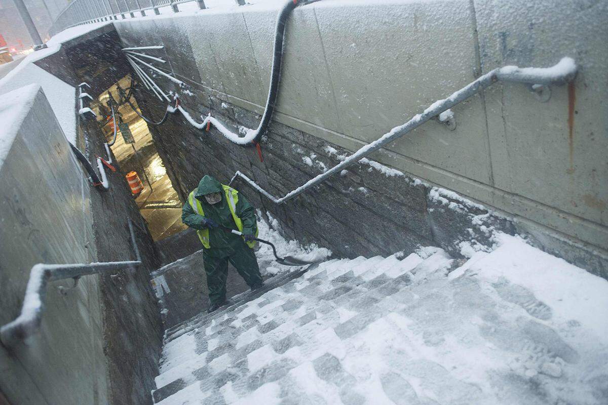 Der Blizzard legte das öffentliche Leben weitgehend lahm. Zahlreiche Städte meldeten Schneefall in Rekordhöhe, etwa Milford im Bundesstaat Connecticut, wo 95 Zentimeter Neuschnee gemessen wurden. Im Bild: Ein New Yorker Straßenarbeiter schaufelt den Weg eines Abgangs frei.