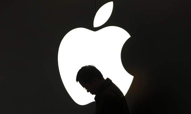 File photo of a man looking at his Apple iPad in front an Apple logo outside an Apple store in downtown Shanghai
