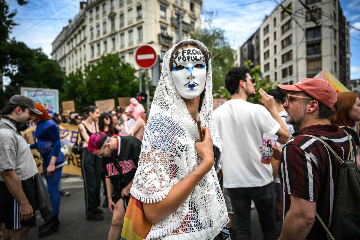 16. Juni. Eine maskierte Demonstrantin zeigt sich mit der Aufschrift „Front Populaire“ in Lyon, Ostfrankreich. Sie protestiert zwei Wochen vor den geplanten Neuwahlen in Frankreich gegen Rechtsextremismus und Rechtspopulismus.