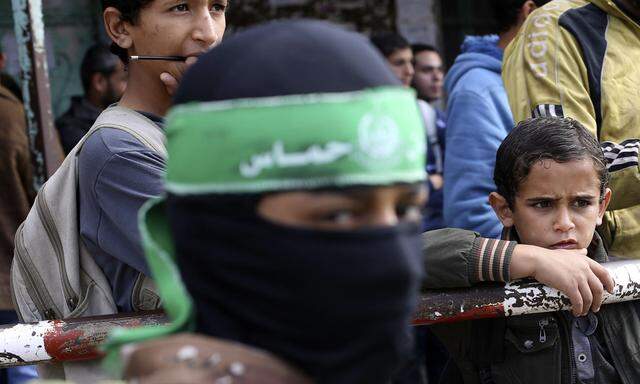 Masked boy wearing a Hamas headband and other Palestinians take part in a protest against what they say are recent visits by Jewish activists to al-Aqsa mosque, in Rafah in the southern Gaza Strip