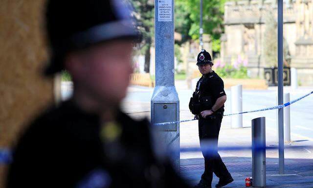 Police officers stand on duty at the cordon surrounding the Manchester Arena in Manchester