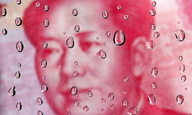 File photo of a portrait of former Chinese leader Mao Zedong on a yuan banknote reflected in water droplets in this picture illustration taken in Taipei