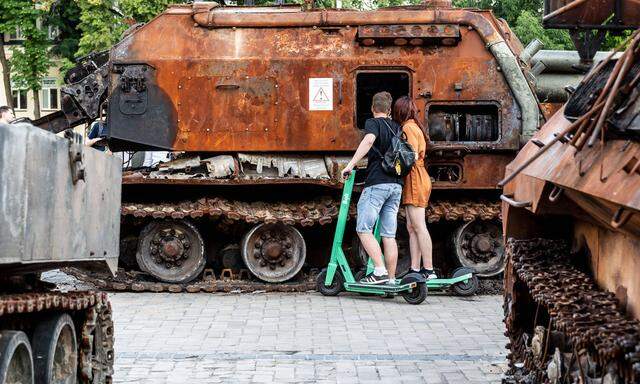 Jugendliche in Kiew besichtigen ausgebrannte russische Panzer. 
