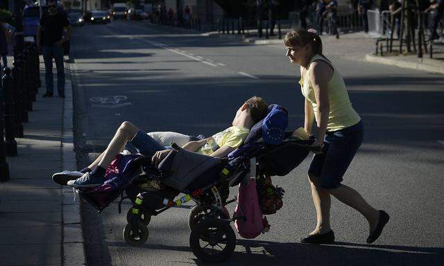 May 12 2018 A woman carries a disabled man on a wheelchair in Warsaw Poland on May 12 2018 duri