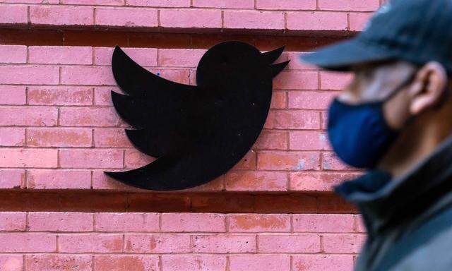 October 14, 2020, New York, United States: A man wearing a face mask walks past a Twitter logo outside New York City hea