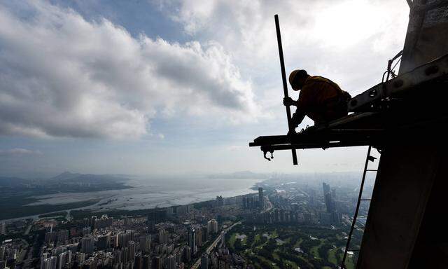 A worker braves the scorching heat as he dismantles scaffold on the top of the PingAn International