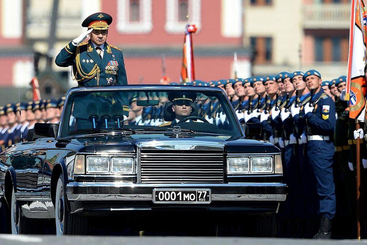 Der russische Verteidigungsminsiter Sergei Kuschugetowitsch Schoigu fährt salutierend an Präsident Putin vorbei.
