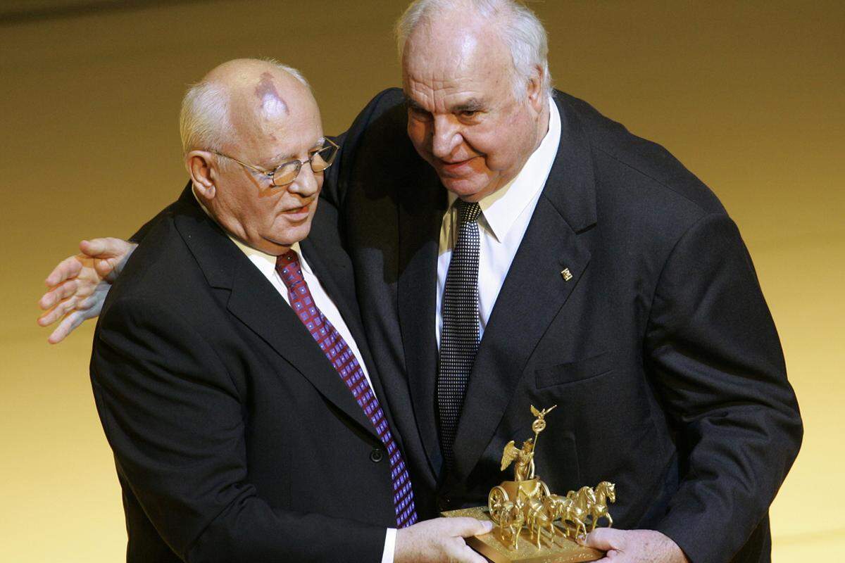 Im Juli 1990 stimmt Gorbatschow bei einem Treffen mit dem deutschen Bundeskanzler Helmut Kohl der deutschen Wiedervereinigung zu. Im selben Jahr erhält er den Friedensnobelpreis.