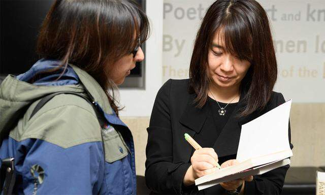 Han Kang signiert ein Exemplar ihres Buchs 