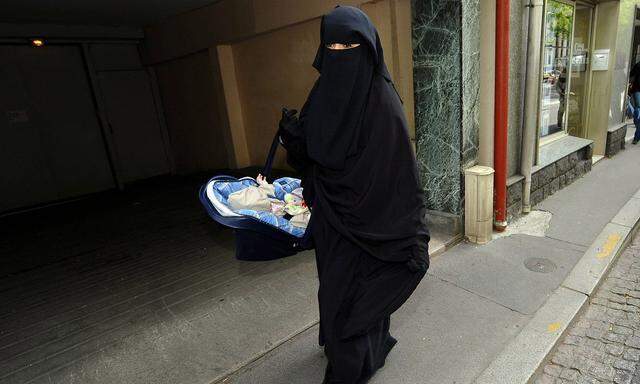 Symbolbild: Frau, die eine Burka trägt, mit Kind am Arm