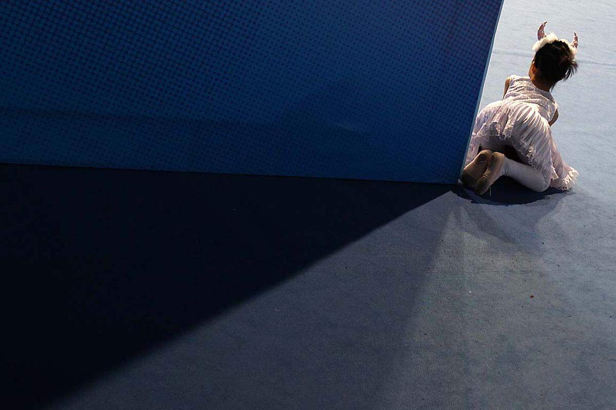 Ein kleines Mädchen mit Teufelshörner schaut bei der Entscheidung im Badminton bei den 16. Asien-Spielen zu.