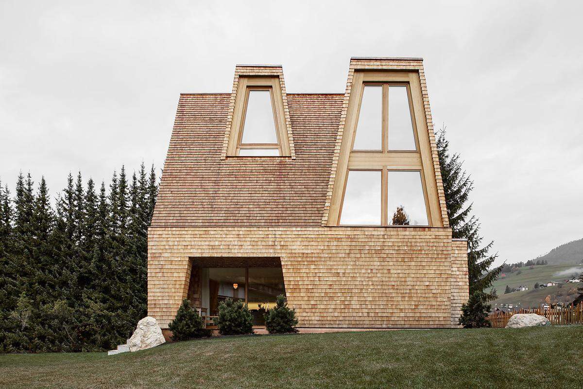 Pedevilla Architekten aus Bruneck (Italien) zeichnen für "Das Holzhaus" verantwortlich und erhielten im Zuge des Häuser Awards eine Auszeichnung. "Die aufstrebende Form des Daches macht das Gebäude schon von weitem sichtbar, die tiefliegende Trauflinie vermittelt Schutz."