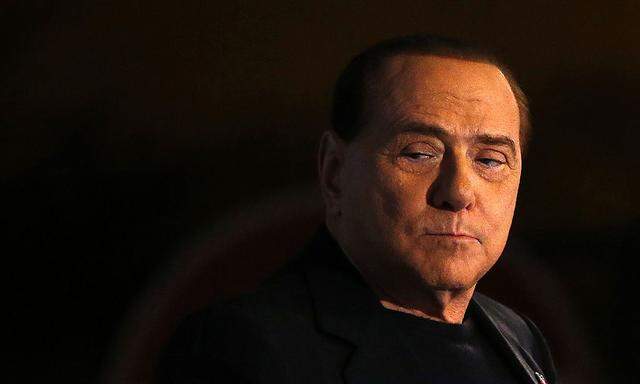 Former Prime Minister Silvio Berlusconi looks on during a speech from the stage in downtown Rome