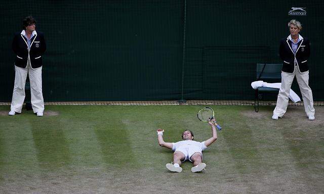Richard Gasquet of France falls to the floor after winning his match against Stan Wawrinka of Switzerland at the Wimbledon Tennis Championships in London