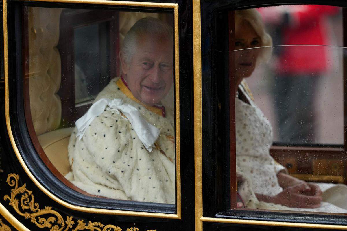 In weiße Gewänder gehüllt zeigten sich König Charles III. und Königin Camilla in der Kutsche. 