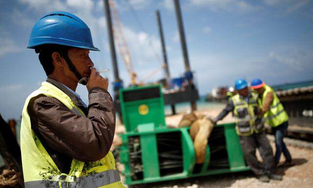 Chinese construction workers work during a media tour of the construction of a new port in the southern city of Ashdod