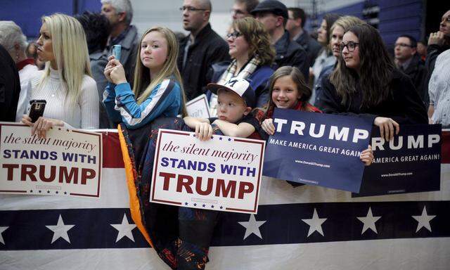 Audience members listen as U.S. Republican presidential candidate Donald Trump speaks at a campaign rally in Marshalltown