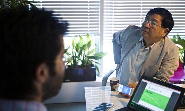 Founder of the ZhenFund seed fund Xu listens to Israeli high-tech firm ironSource's CEO Bar Zeev during a presentation in Tel Aviv