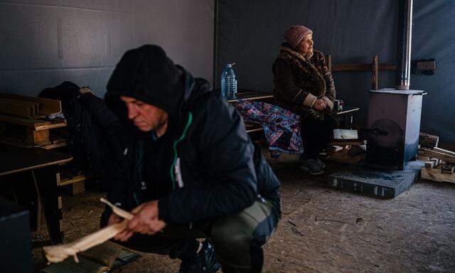 Es wird ein harter Kriegswinter in der Ukraine: Ein Mann beheizt einen Holzofen in einem Wärmezelt in Borodjanka im Kiewer Umland. 