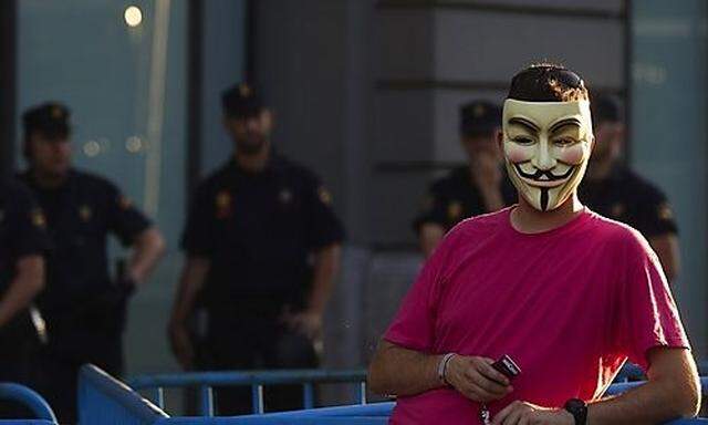 A demonstrator wearing an Anonymous group mask attends an assembly against the Euro Pact and the 