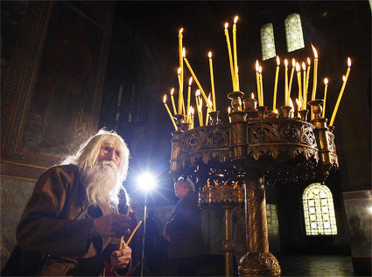 Während Katholiken die Auferstehung Jesu feiern, zelebriert die orthodoxe Kirche den Palmsonntag. Hier zündet ein Mann in der Kathedrale von Sofia eine Kerze an.