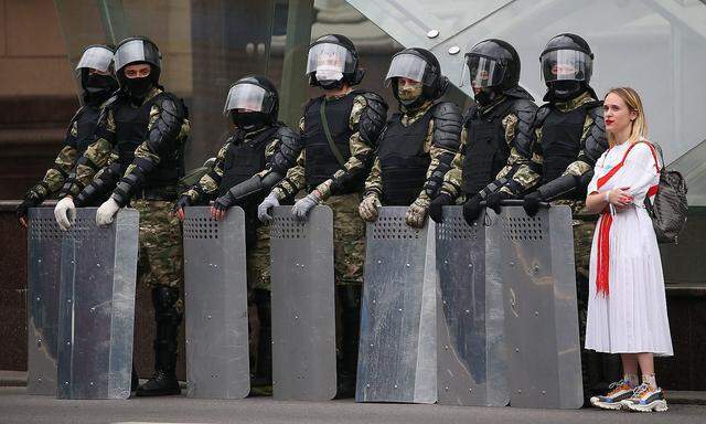 Eine Demonstrantin im September 2020 neben Einsatzkräften in der belarussischen Hauptstadt, Minsk