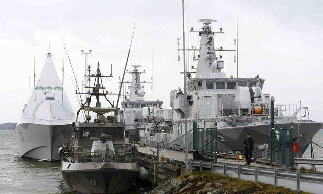 HMS Visby and two minesweepers lie moored at the jetty at Berga marine base outside Stockholm