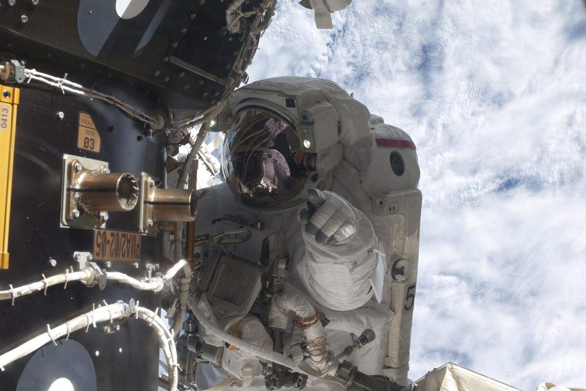 Der Astronaut Mike Fossum bei dem letzten Außeneinsatz in der Shuttle-Ära. Eine defekte Kühlpumpe musste von der Internationalen Raumstation ISS abmontiert und anschließend in der Raumfähre "Atlantis" verstaut werden.