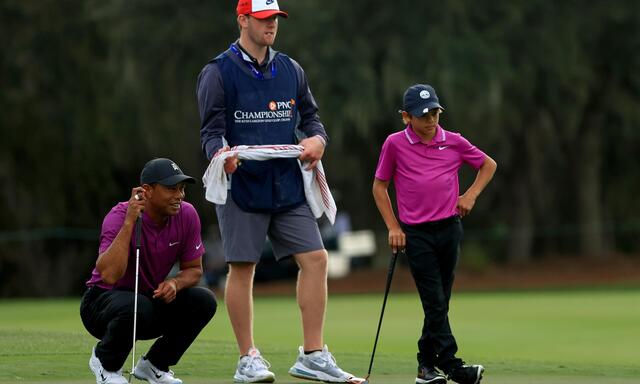 Der Vater schaut, der Caddy überlegt und  Charlie Woods wagt den Putt.