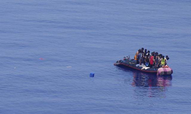 Migrants are seen crammed onto a rubber dinghy before being saved by Italian Navy rescue at about 100 miles from the southern coast of the Sicilian island of Lampedusa