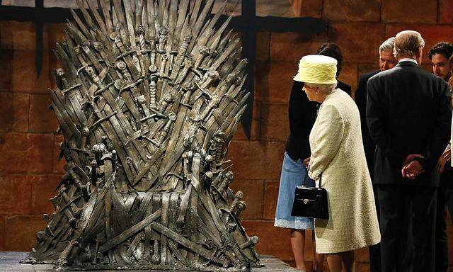 Britain´s Queen Elizabeth looks at the Iron Throne as she meets cast members on the set of TV series Game of Thrones in Belfast