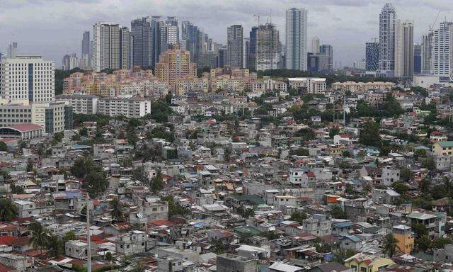 A poor residential district and squatter colonies are overlooked by high rise residential and commercial buildings in Taguig