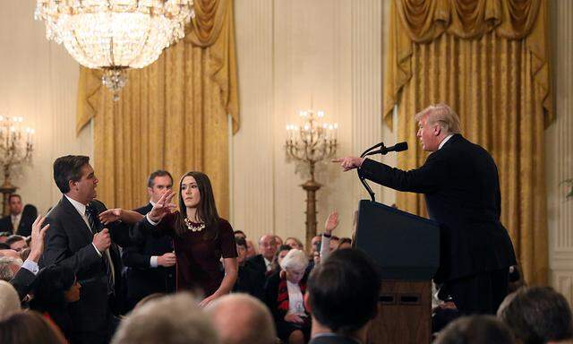 A White House staff member reaches for the microphone held by CNN´s Jim Acosta as he questions U.S. President Donald Trump during a news conference in Washington