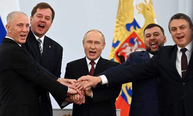 Wladimir Putin und die vier Separatistenführer legten nach Unterzeichnung der völkerrechtswidrigen Beitrittspapiere die Hände übereinander und skandierten: „Russland, Russland.“
