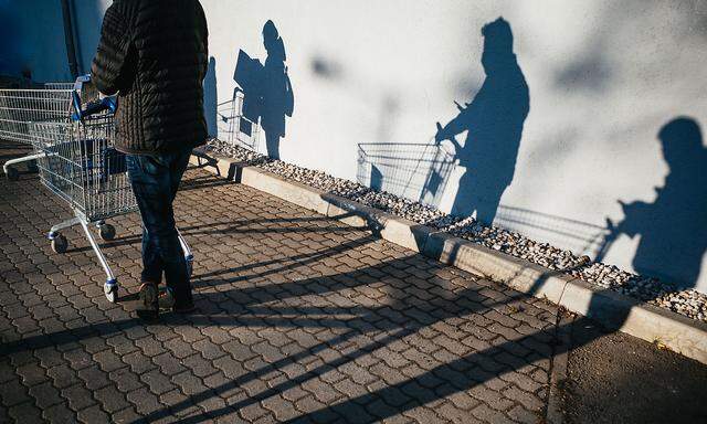 Rear View Of Shadow Of People Pushing Shopping Cart