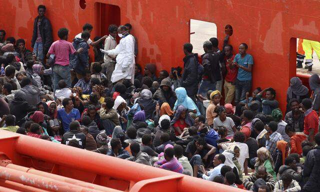 Migrants are seen aboard a navy ship before being disembarked in the Sicilian harbour of Augusta