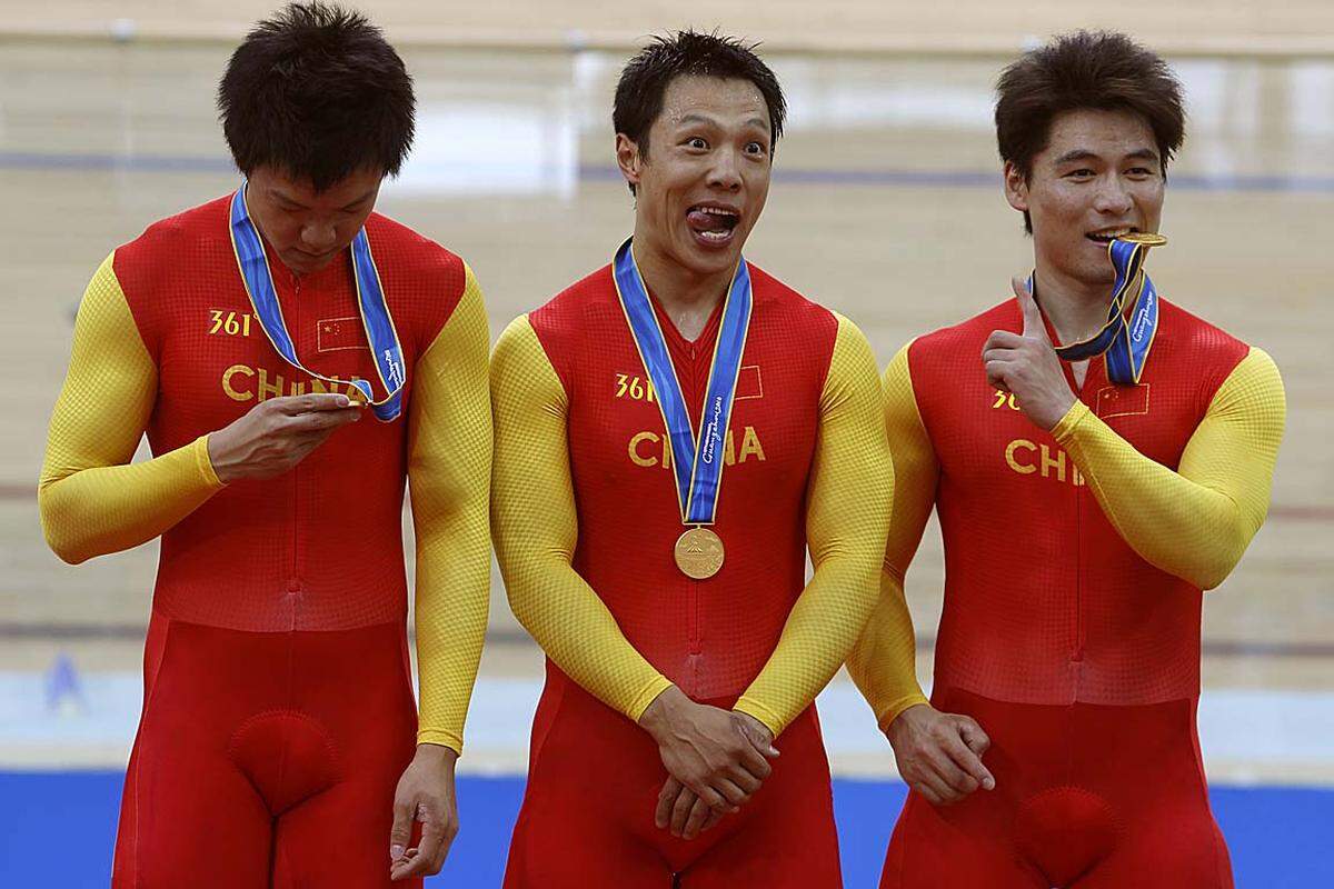 Drei Kasperl mit Goldmedaille: Das chinesische Radsprintteam Zhang Lei, Zhang Miao und Cheng Changsong feiert auf seine ganz eigene Art den Triumph bei den 16. Asien-Spielen.
