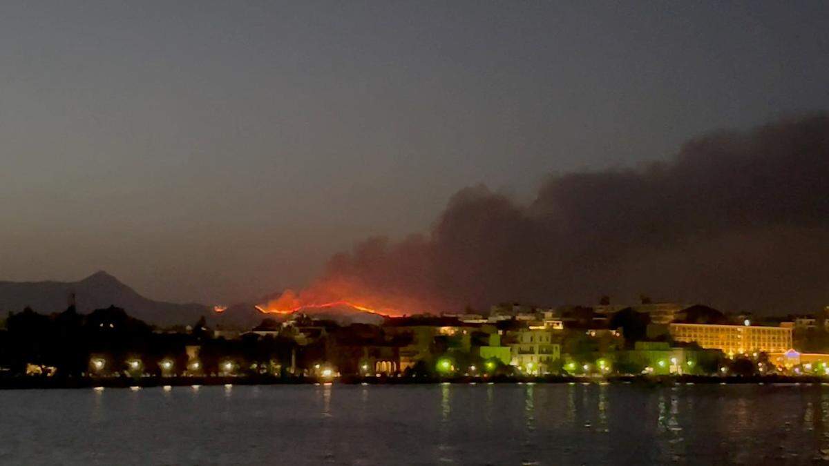 Rauch steigt von einem Waldbrand auf der Insel Korfu auf. Die beliebte Ferienortschaft Nisaki wird geräumt.