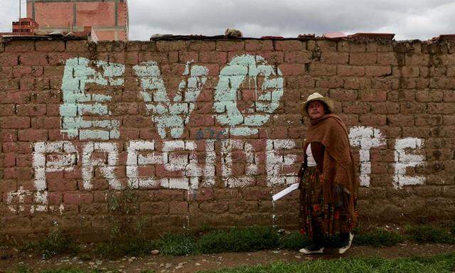 A woman walks in front of a wall reading ´Evo (Morales) President´ in El Alto, on the outskirts of La Paz