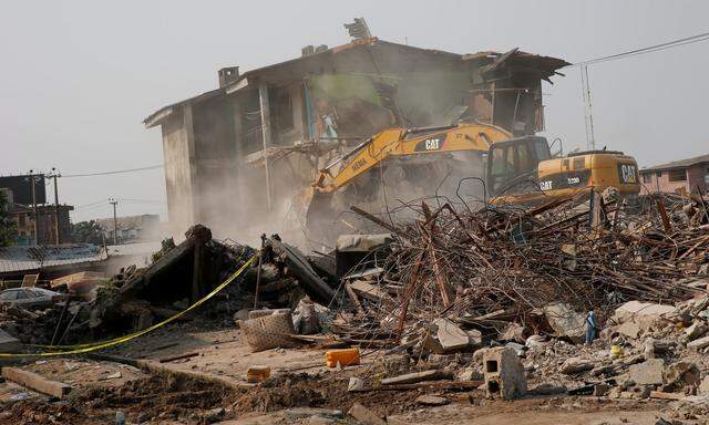 An excavator is seen at the site of the collapse of of a two-storey building in a police training college in Ikeja district, Lagos, Nigeria