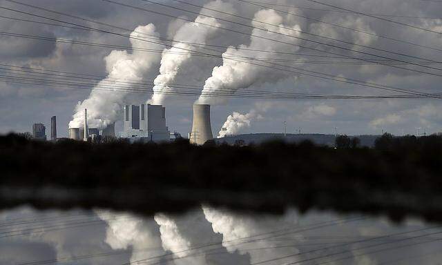 The coal power plant of German utility RWE Power is reflected in water near the western town of Neurath