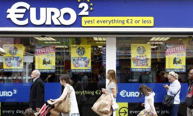 Pedestrian's walk past a discount store on Moore Street in Dublin